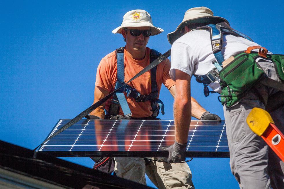 ReVision Energy employees Steve Dzubak (left) and Jared Cobb install a solar panel on the roof of a Concord home on Thursday, Aug. 27, 2015. In total, 25 panels will be installed and will supply the homeowner with more power than he is expected to use.  (ELIZABETH FRANTZ / Monitor staff)