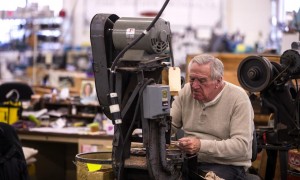Howard Engel of Page Belting works on cutting out holes for custom knife sheaths at the company's Boscawen plant on High Street Monday.  (GEOFF FORESTER / Monitor staff) - GEOFF FORESTER | Concord Monitor