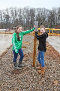 Strafford School 6th-graders Rylee Barry, left, and Elizabeth Marston pour at the CoCoRaHS rain gauge at their school. (Courtesy photo) -