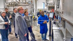 Hosea Hobbs, a process technician for Nanocomp Technologies in Merrimack, describes how furnaces turn carbon nanotubes into high-tech yarn during a tour by U.S. Sen. Jeanne Shaheen and, to her right, NASA space technology administrator Jim Reuter. Oct. 29, 2018. David Brooks—Monitor staff