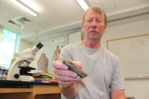 Fred Prince, PSU professor, with a mammoth tooth in 2014. Credit Bruce Lyndes / Plymouth State University