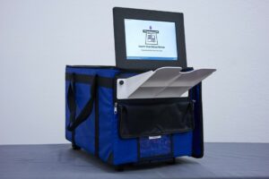 A VotingWorks machine. The paper ballot, previously marked by pencil, is placed on the tray, drawn into the machine and read. The screen tells voters whether any errors were found.