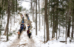 A group of 60 people participated in a winter tour on Saturday, February 14, 2026, organized by the Forest Society and UNH Cooperative Extension. This tour focused on an ongoing timber harvest located off Dudley Pond Road in Henniker. One of the highlights of the tour was a clear-cut area, which was one of several types of timber clearing explored. The trees and branches left scattered around the hill are intentionally left behind and are referred to as "slash."